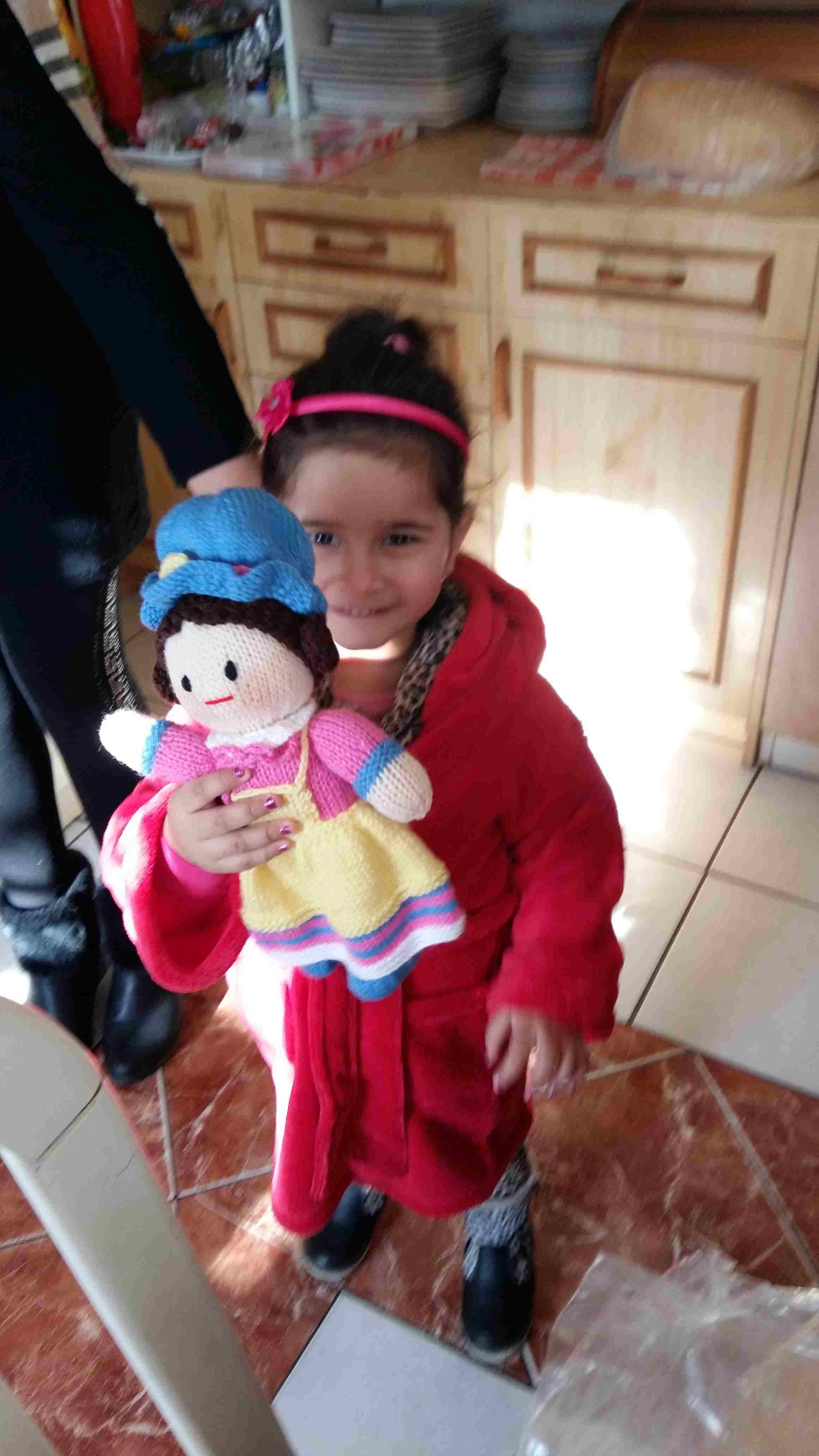 Pastor Katis Grand daughter from Nyirbeltek with dolly
        knitted by the Women of Wales knitting Group